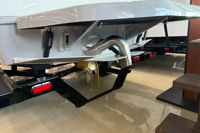 Slide: The Image of 2026 Moomba Craz boat trailer with propeller and exhaust system in showroom. - 7