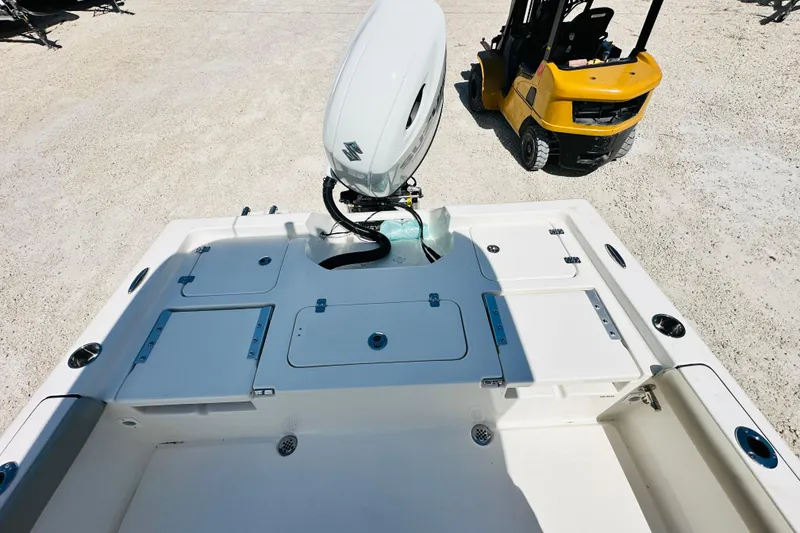 Slide: The Image of 2026 Key West 230 Bay Reef boat with outboard motor and forklift nearby. - 8