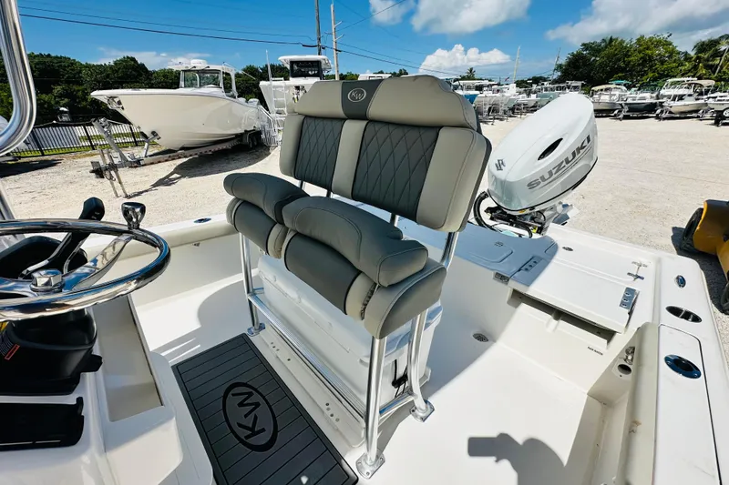 Slide: The Image of 2026 Key West 230 Bay Reef boat interior with seating and Suzuki outboard motor. - 9