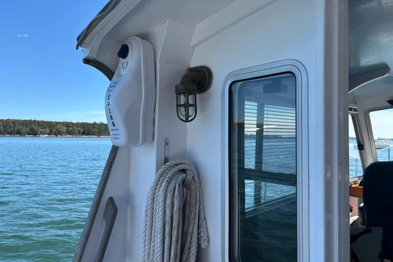 Slide: The Image of 1985 Jarvis Newman 36 boat with EPIRB, rope, and scenic ocean view. - 14