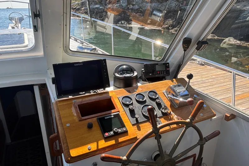 Slide: The Image of 1985 Jarvis Newman 36 boat helm with wooden wheel and navigation instruments. - 19