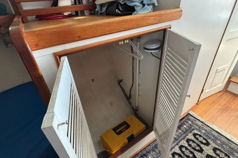 Slide: The Image of Open storage cabinet on 1985 Jarvis Newman 36 boat with yellow toolbox inside. - 33