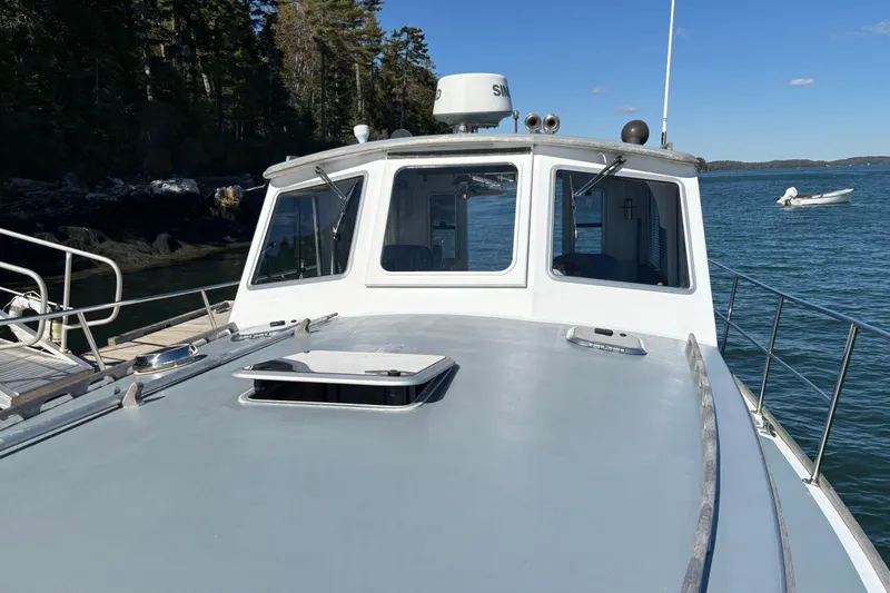 Slide: The Image of 1985 Jarvis Newman 36 boat docked by a scenic shoreline. - 46