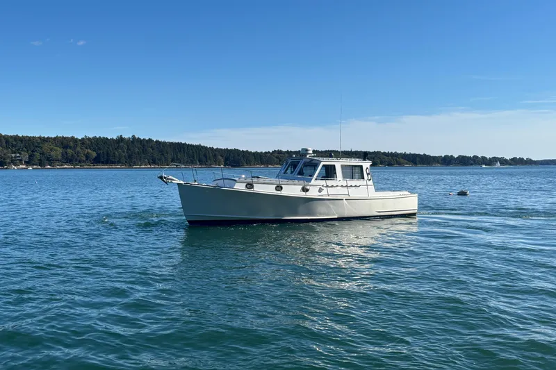 Slide: The Image of 1985 Jarvis Newman 36 boat on calm water under clear blue sky. - 55