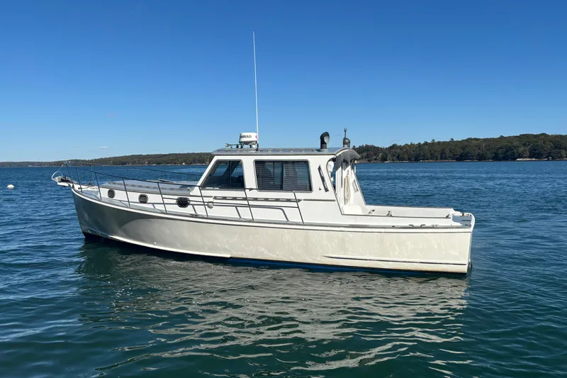 Slide: The Image of 1985 Jarvis Newman 36 boat on calm water under clear blue sky. - 56