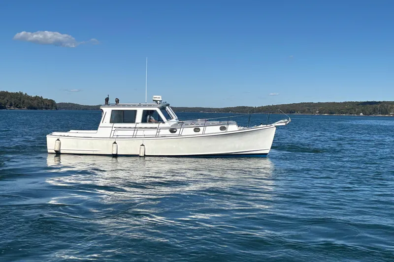 Slide: The Image of 1985 Jarvis Newman 36 boat on calm water under clear blue sky. - 57