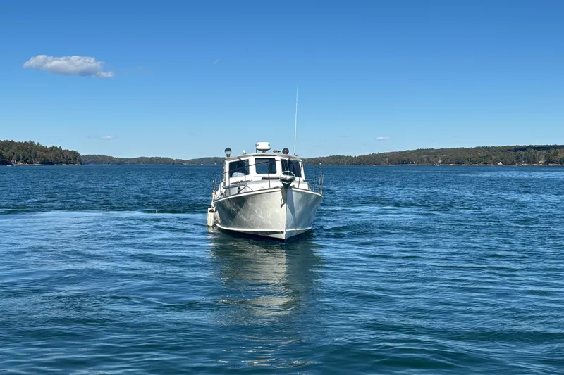 Slide: The Image of 1985 Jarvis Newman 36 boat on calm blue water under clear sky. - 58