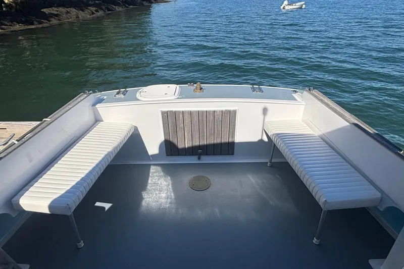 Slide: The Image of 1985 Jarvis Newman 36 boat deck with white seating, docked by calm waters. - 7