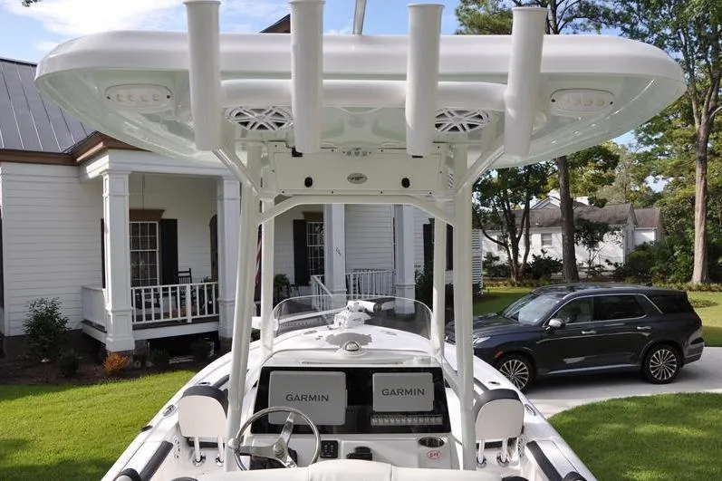 Slide: The Image of 2024 Tidewater 2300 Carolina Bay boat with Garmin displays, parked near a house and car. - 11