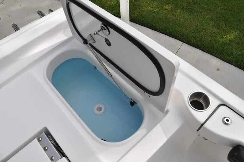Slide: The Image of 2024 Tidewater 2300 Carolina Bay boat livewell with open lid, showcasing interior features. - 18