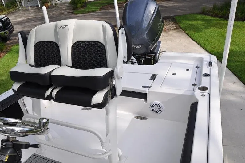Slide: The Image of 2024 Tidewater 2300 Carolina Bay boat interior with dual seats and motor. - 19