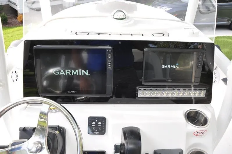 Slide: The Image of 2024 Tidewater 2300 Carolina Bay dashboard with Garmin navigation displays and controls. - 21