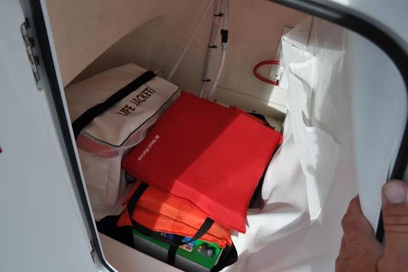 Slide: The Image of Storage compartment in 2024 Tidewater 2300 Carolina Bay with life jackets and safety gear. - 30