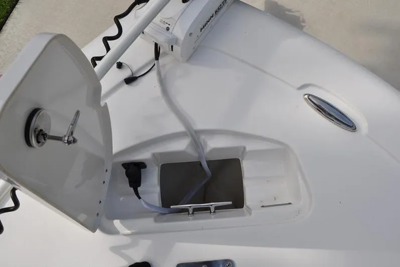 Slide: The Image of 2024 Tidewater 2300 Carolina Bay boat with open storage compartment and trolling motor. - 36