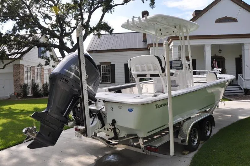 Slide: The Image of 2024 Tidewater 2300 Carolina Bay boat on trailer in front of a house. - 4