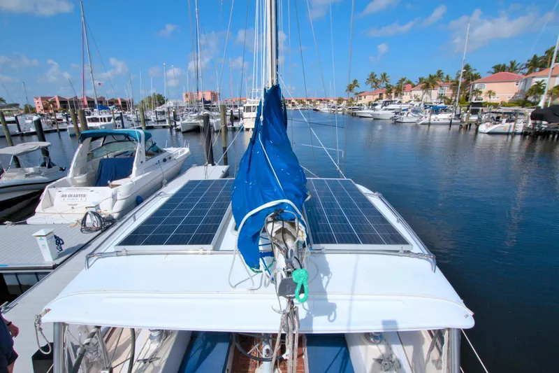 Slide: The Image of 1987 Morgan 43 CC sailboat with solar panels docked in a marina under a clear blue sky. - 14