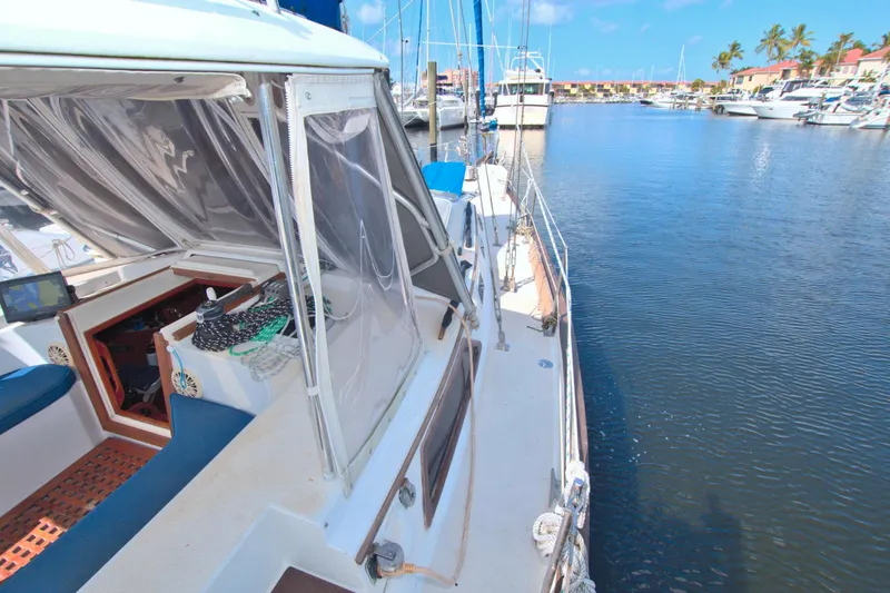 Slide: The Image of 1987 Morgan 43 CC sailboat docked in a sunny marina, featuring a spacious cockpit. - 16