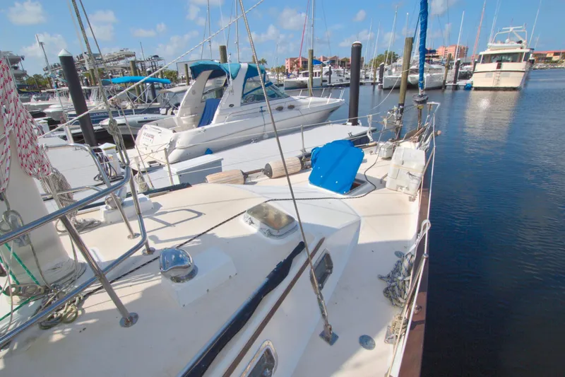 Slide: The Image of 1987 Morgan 43 CC sailboat docked in a marina, surrounded by other boats. - 18