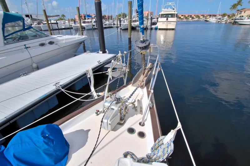 Slide: The Image of 1987 Morgan 43 CC sailboat docked in a marina, surrounded by other boats. - 19