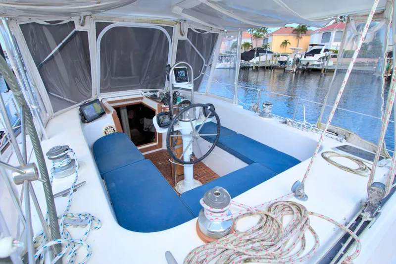 Slide: The Image of 1987 Morgan 43 CC sailboat cockpit with blue seating, steering wheel, and navigation equipment. - 24