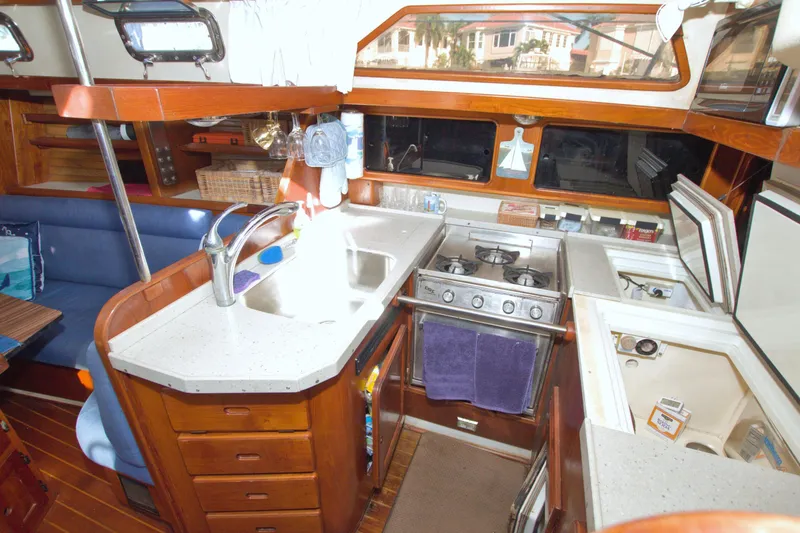 Slide: The Image of 1987 Morgan 43 CC yacht interior kitchen with stove, sink, and seating area. - 36