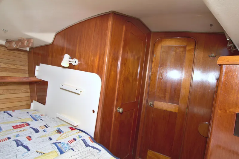 Slide: The Image of 1987 Morgan 43 CC yacht interior with wooden paneling and cozy cabin bed. - 47
