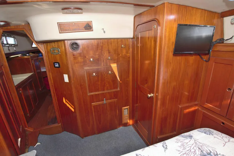 Slide: The Image of Interior of 1987 Morgan 43 CC yacht with wooden cabinetry and mounted TV. - 56