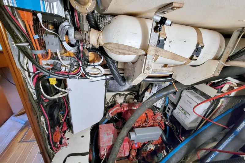 Slide: The Image of Engine room of a 1987 Morgan 43 CC sailboat, showcasing wiring and mechanical components. - 64