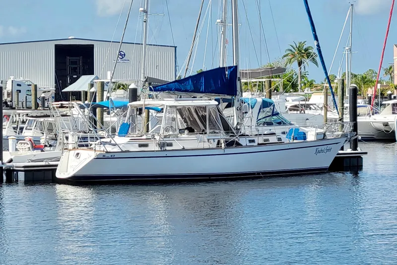 Slide: The Image of 1987 Morgan 43 CC sailboat docked at marina, blue canopy, calm water. - 73