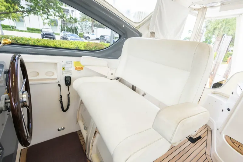 Slide: The Image of Interior of 2000 Tiara Yachts 5200 Express with white captain's seat and steering wheel. - 10