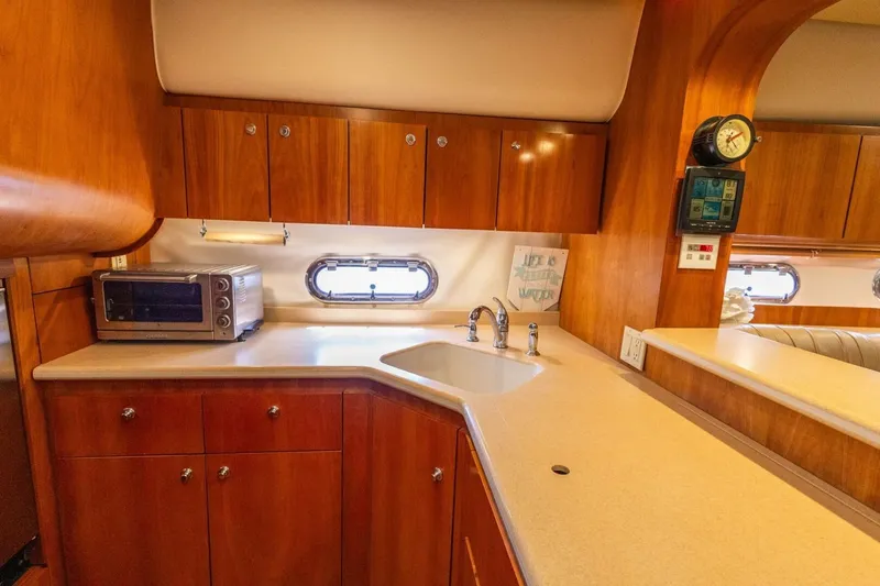 Slide: The Image of Luxurious 2000 Tiara Yachts 5200 Express kitchen with wood cabinetry and modern appliances. - 12
