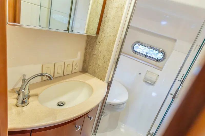 Slide: The Image of Luxurious bathroom in 2000 Tiara Yachts 5200 Express, featuring modern sink and porthole window. - 19
