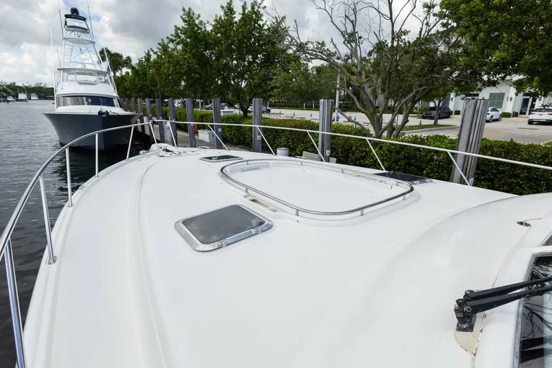 Slide: The Image of 2000 Tiara Yachts 5200 Express docked, showcasing sleek deck design and marina setting. - 23