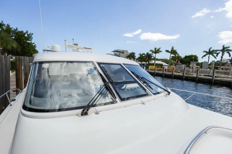 Slide: The Image of 2000 Tiara Yachts 5200 Express docked near palm trees and waterfront. - 26