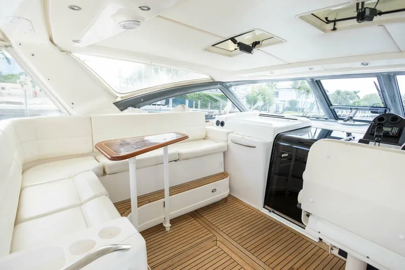 Slide: The Image of Luxurious interior of 2000 Tiara Yachts 5200 Express with white seating and wooden flooring. - 7