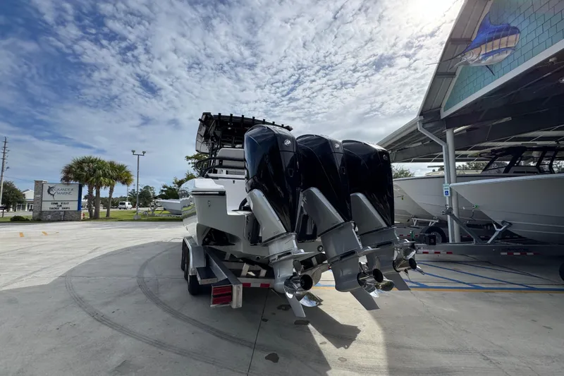 Slide: The Image of 2026 Fountain 34 Tournament Edition boat with triple outboard engines at a marina. - 12