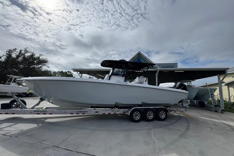 Slide: The Image of 2026 Fountain 34 Tournament Edition boat on trailer under cloudy sky. - 2