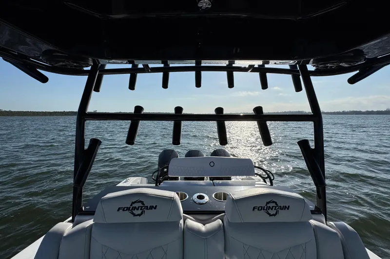 Slide: The Image of 2026 Fountain 34 Tournament Edition boat on water, rear view with rod holders and seating. - 32