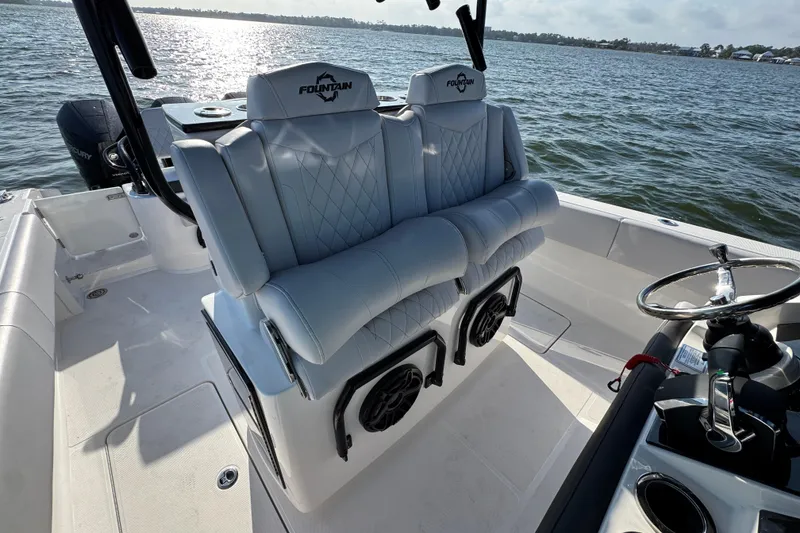 Slide: The Image of 2026 Fountain 34 Tournament Edition boat interior with luxury seating and steering wheel on open water. - 33