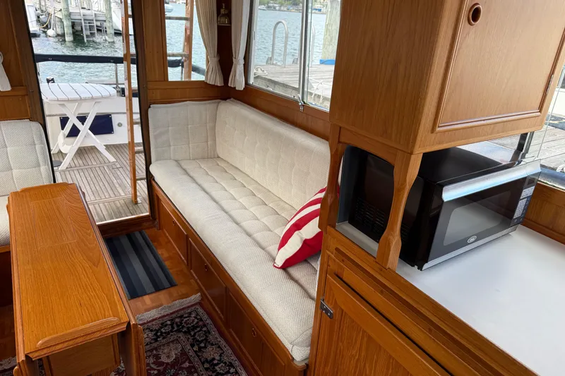 Slide: The Image of Interior of a 1989 Grand Banks 32 Sedan with wood finish and cozy seating. - 12