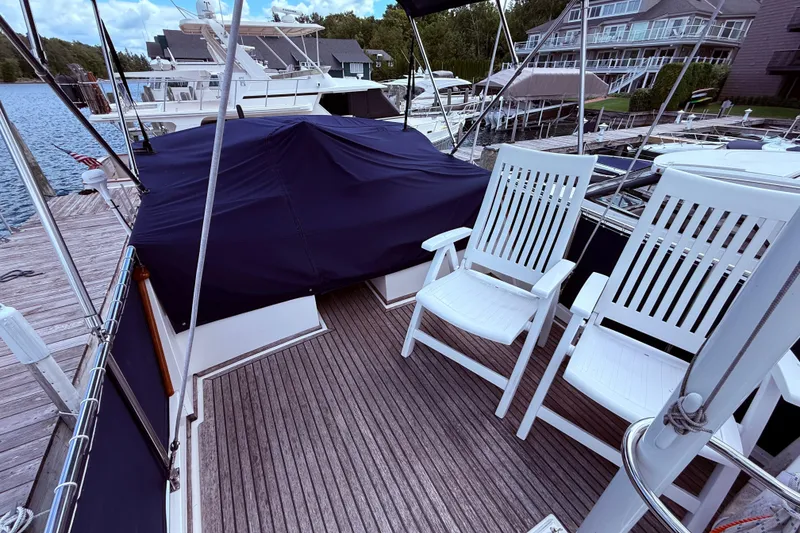 Slide: The Image of 1989 Grand Banks 32 Sedan yacht deck with white chairs, docked at marina. - 13