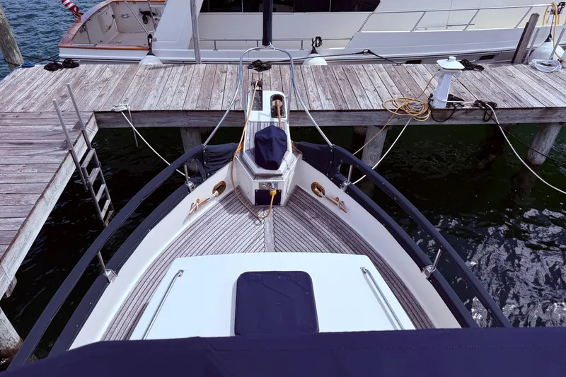 Slide: The Image of 1989 Grand Banks 32 Sedan docked at a wooden pier, viewed from above. - 17