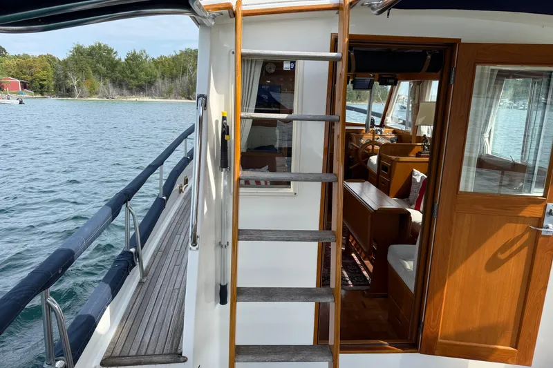 Slide: The Image of 1989 Grand Banks 32 Sedan boat interior with wooden ladder and open cabin door. - 22