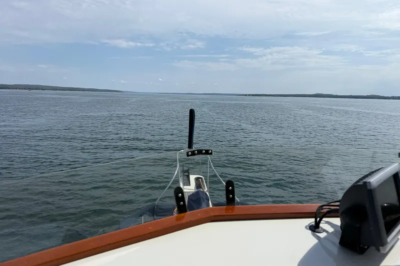 Slide: The Image of 1989 Grand Banks 32 Sedan cruising on open water under a clear sky. - 24