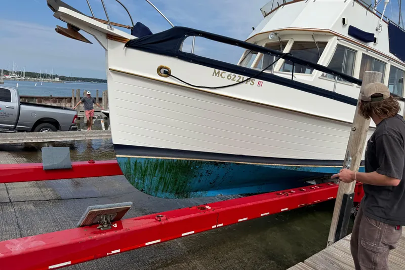 Slide: The Image of 1989 Grand Banks 32 Sedan being lifted from water at a marina. - 25