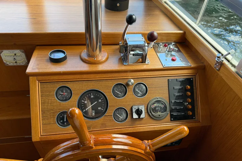 Slide: The Image of 1989 Grand Banks 32 Sedan helm with wooden wheel, gauges, and controls. - 6
