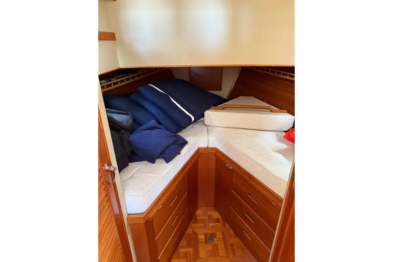 Slide: The Image of 1989 Grand Banks 32 Sedan cabin interior with cozy bedding and wooden storage. - 8