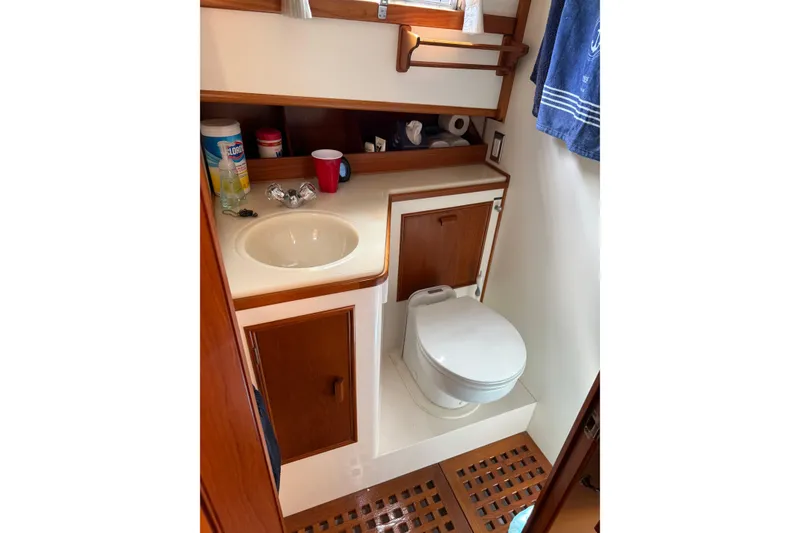 Slide: The Image of 1989 Grand Banks 32 Sedan bathroom with sink, toilet, and wooden cabinetry. - 9