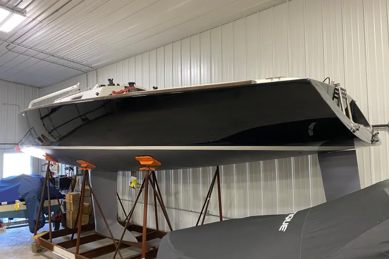 Slide: The Image of 2014 J Boats J/100 sailboat in storage, elevated on stands in a warehouse. - 2