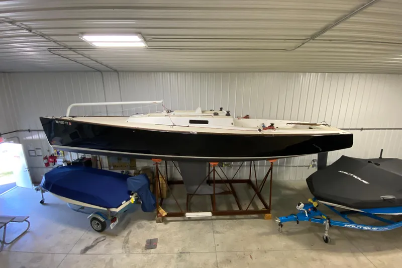Slide: The Image of 2014 J Boats J/100 sailboat in storage, black hull, indoor facility. - 4